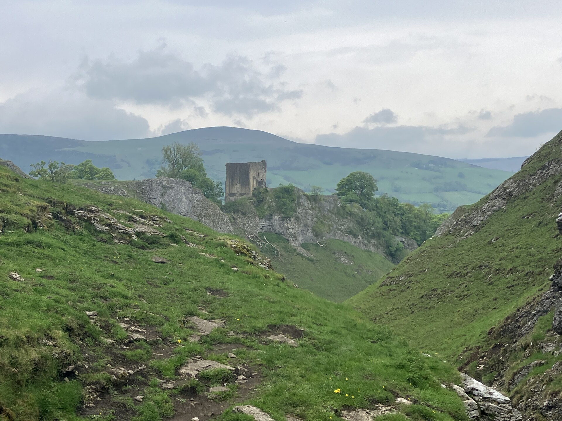 Peveril Castle ruins seen from Cave Dale, wider view