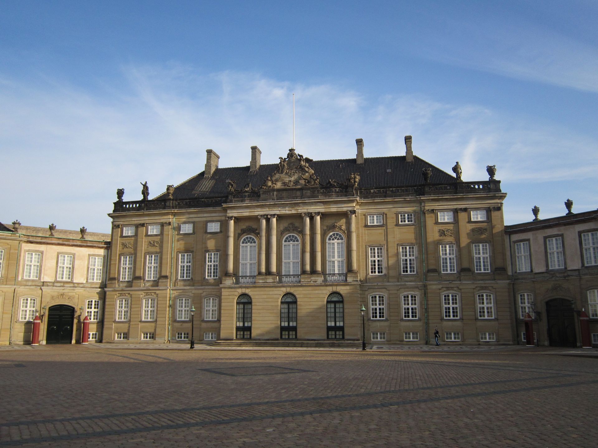 Amalienborg Palace facade with statues under blue sky