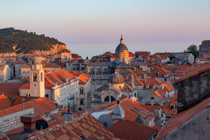 Rooftop view of cathedral dome at dusk with hillside