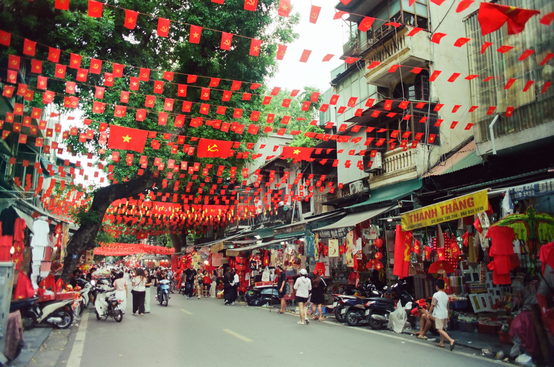 Crowded shopping street decked with red flags and lanterns