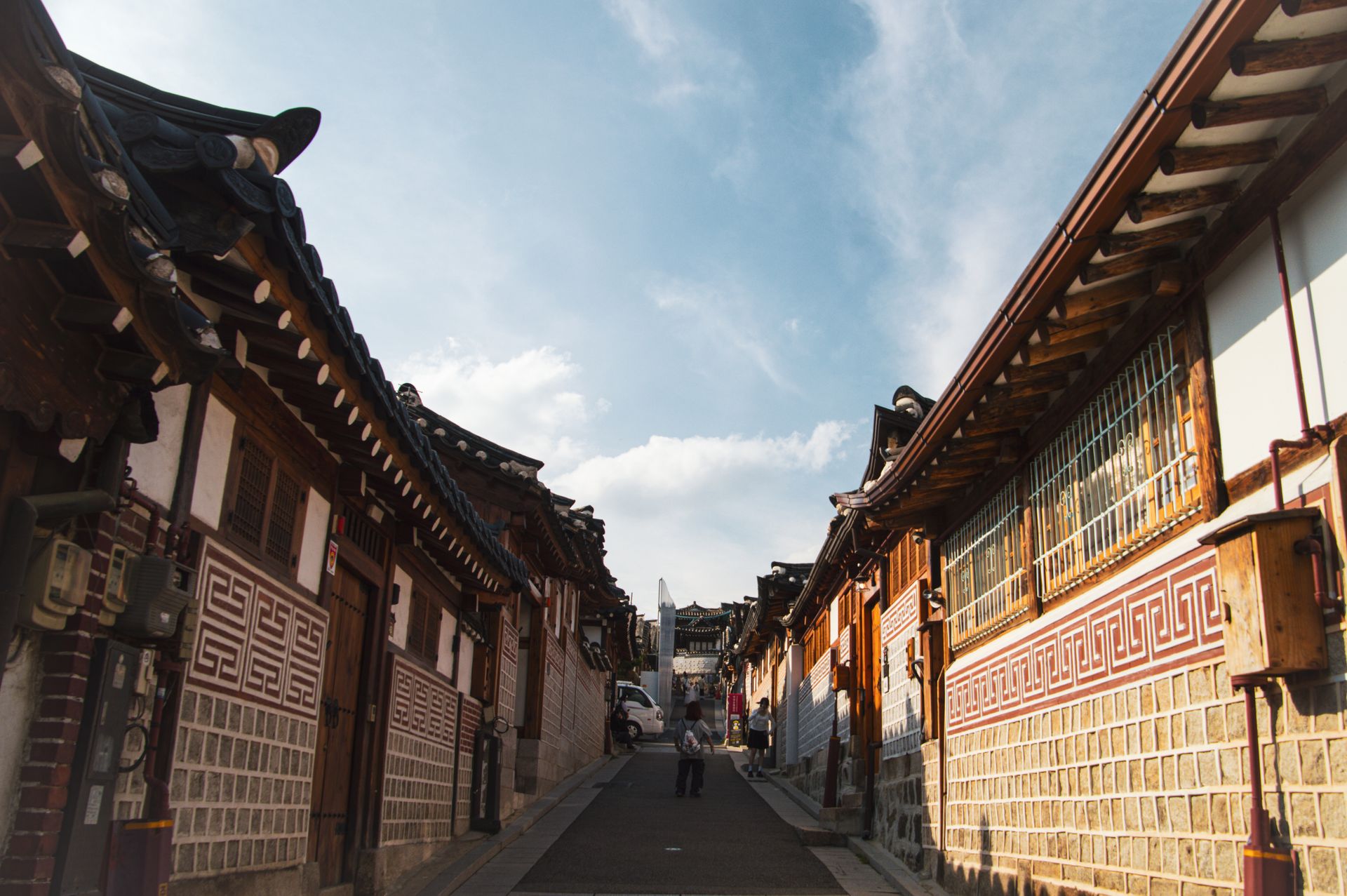 Empty hanok lane with tiled roofs under blue sky