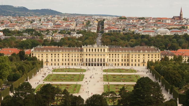 Aerial view of palace facade with gardens and Vienna skyline
