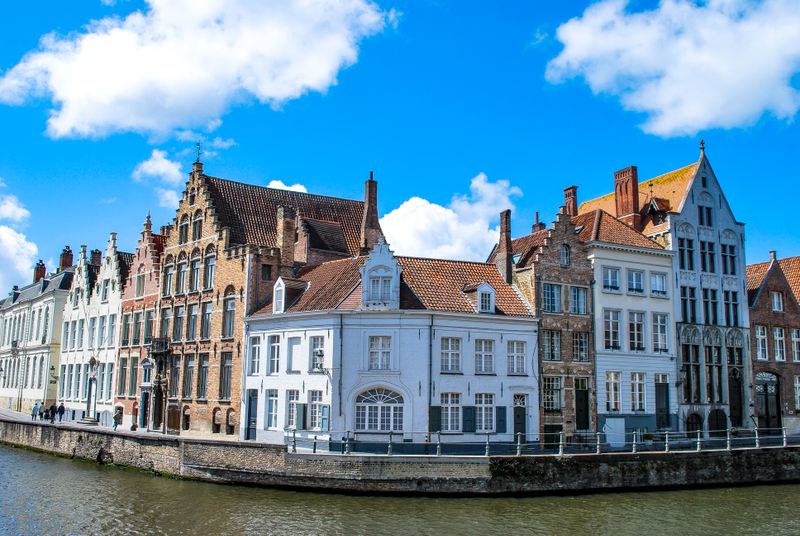 Row of gabled canal houses under bright blue sky