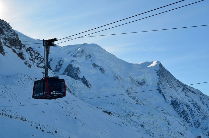 Cable car ascending toward snow-covered Mont Blanc summit