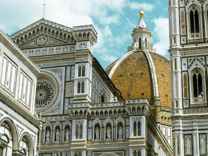Close view of the gold-hued dome and ornate facade