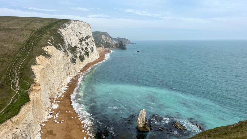 Aerial view of white cliffs above turquoise sea and rock stack