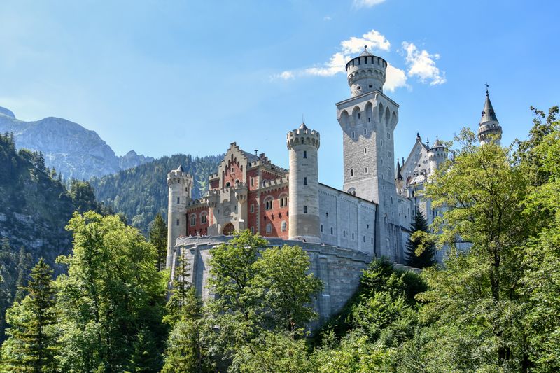 Close-up of castle towers framed by lush green trees