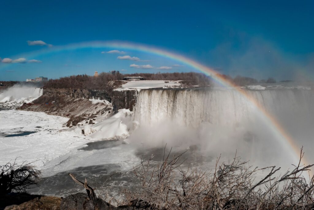 Niagara Falls with a rainbow under a clear blue sky